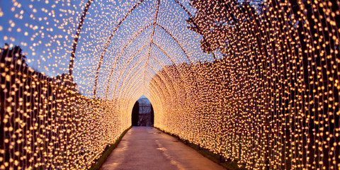 Christmas decoration. Colourful decor lights lantern tunnel in the city during winter.