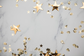 Gold star sparkle party confetti on a marble flat lay background