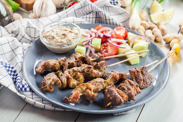 Traditional pork satay with peanut sauce and vegetables