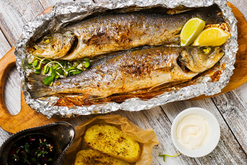 Fresh baked fish sea bass (Dicentrarchus labrax) on a light wooden background