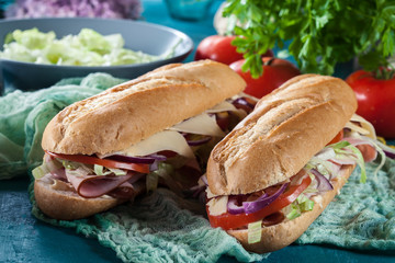 Submarine sandwiches with ham, cheese and vegetables