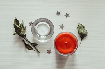 two candles standing on a white wooden background