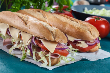 Submarine sandwiches with ham, cheese and vegetables