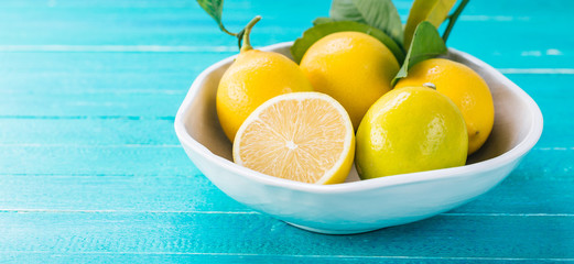 Lemon in a plate on a turquoise wooden background, citrus, vitamin C