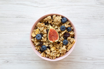 Fruit granola on a white wooden background, overhead view. Flat lay, from above, top view. Closeup.