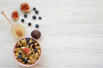 Granola with fruits and honey, overhead view. Flat lay, from above, top view. Copy space.