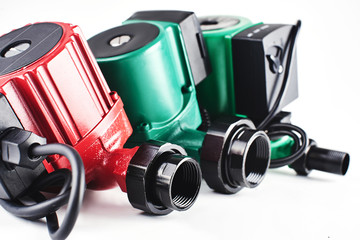 Red and green circulation pumps for heating on a white background.