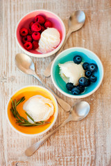 Three cups of ice cream: with blueberries, with raspberries and rosemary