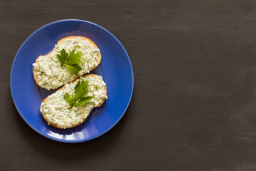 sandwiches with cottage cheese and herbs on a dark background