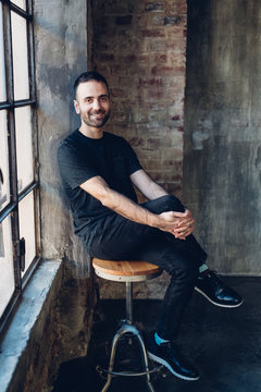 Man sitting on swivel stool by window