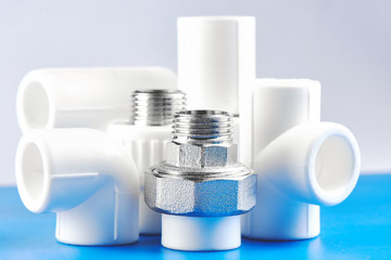 Plumbing parts, accessories and tools on a blue white background.