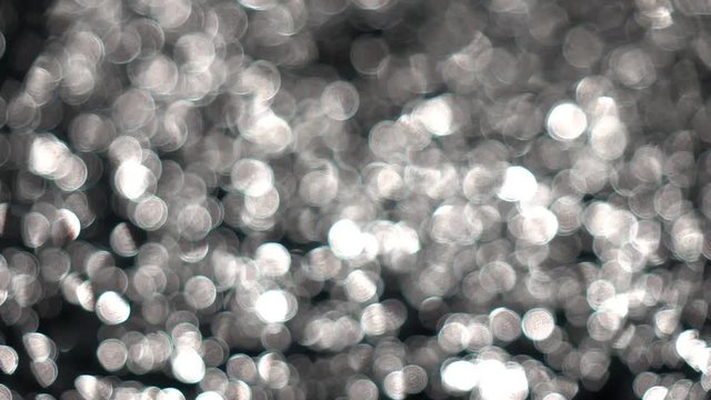 Sea of playing white and gray specks on black background. Amazing vibrant beams out of focus. Play of the silver light. Abstract meditative and relax intro with sparkling gleams.
