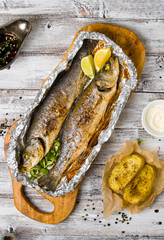 Fresh baked fish sea bass (Dicentrarchus labrax) on a light wooden background