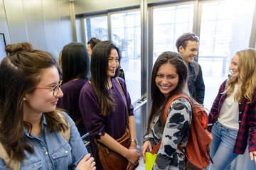 University students talking inside elevator