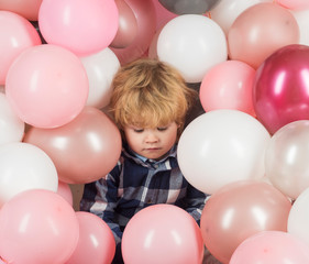 Fototapeta na wymiar Child in balloons. Birthday party. Tired child after holiday. Celebrity life. Pink balloons and sad kid boy. Lonely child without parents is sad and frustrated. Cute baby close up, pink background