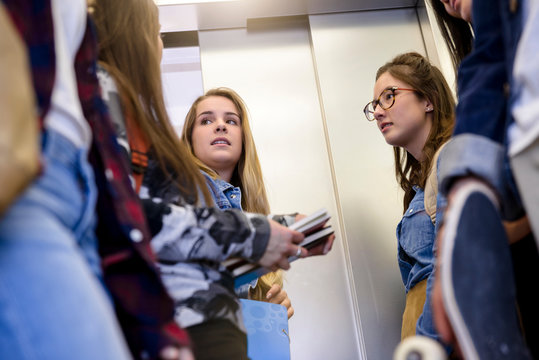 University students talking inside elevator
