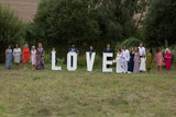 Wedding guests posing behind love word