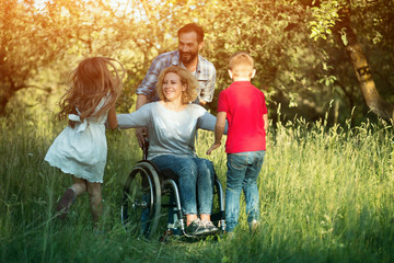Children run to their disabled mother in the park