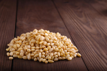 Pine nuts in a bowl on a dark background background.