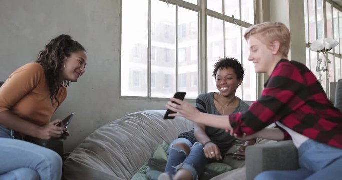 Young adult friends looking at a smartphone together 