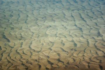 Natural background with sand lines and water