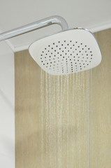 Modern shower head splashing water .