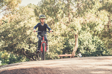 Fototapeta na wymiar Australian boy riding his bicycles on special bike track in Adelaide, South Australia. Low point photo