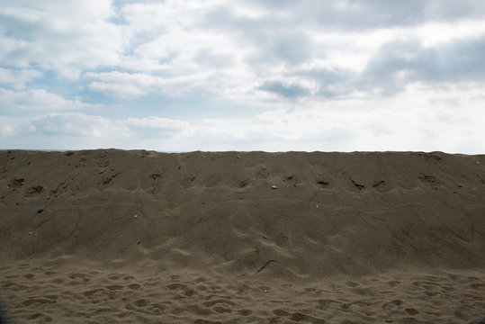 Sand dunes erected to protect buildings built near the beach, the sky is cloudy