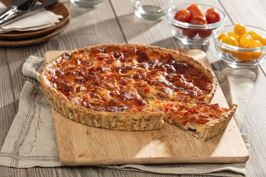 Ham and cheese flan on chopping board, still life