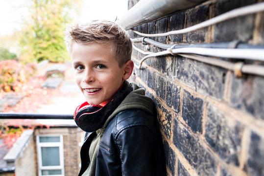 Boy leaning against brickwall