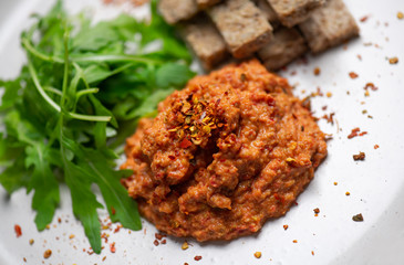 Ajvar served with bread and rucola (arugula)