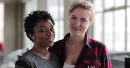Portrait of young lesbian couple in loft apartment