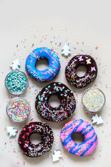 homemade doughnuts with colored frosting and different sprinkles on white background