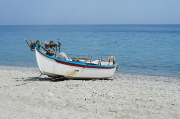 Abandoned fishing boat on beach near sea.