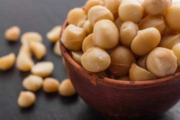 delicious macadamia nuts on a dark stone background