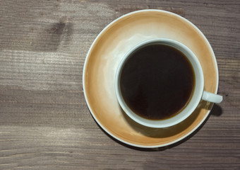 Cup of coffee on dark wooden background.