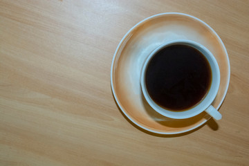 Obraz premium a Cup of coffee on a light wooden table.