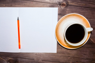 checkered leaf, a Cup of coffee and a heart on a wooden dark table.