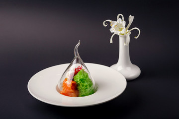 Molecular cuisine gravlax trout with garlic ice cream on a black background
