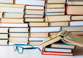 Books background, glasses and notebook on white wooden table