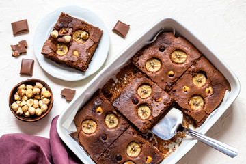 brownie with banana and hazelnut on white background in the form of pieces