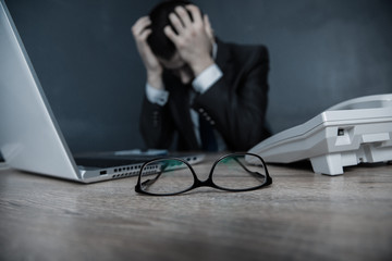 man hand in head with working table