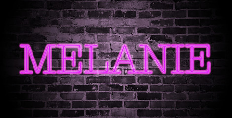 first name Melanie in pink neon on brick wall
