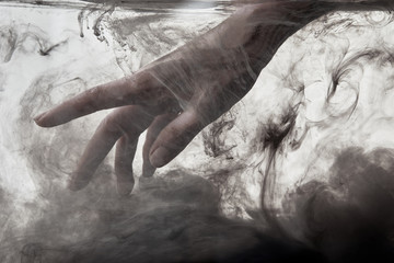 female hand in water with grey paint