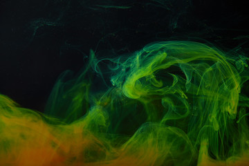 dark background with abstract green and orange swirls of paint