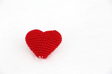 Naklejka na ściany i meble Valentine's day background, red knitted heart in the snow. Symbol of romantic love, concept of blood donation, Christmas mood