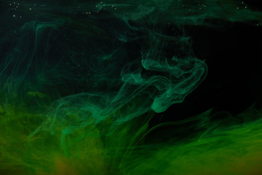 abstract background with green swirls of paint in water