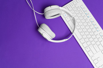 White computer keyboard on a bright purple paper background