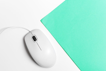 Computer mouse on a turquoise paper background