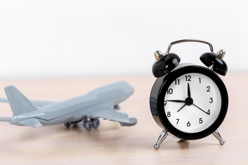 Time to travel concept. plastic plane jet toy passenger with alarm clock